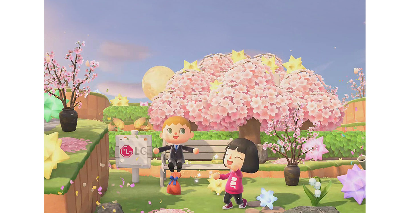 Two player avatars on popular Nintendo game 'Animal Crossing’ play around a cherry blossom tree beside a wooden sign displaying the LG logo.