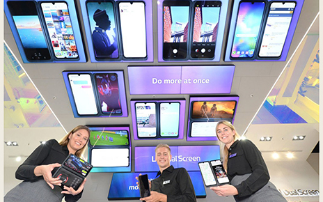 Three models are holding up the new LG G8X ThinQ smartphones with smiles on their faces.