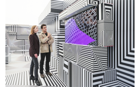 Two visitors taking a closer look at LG OLED-powered “Into the Maze” installation by the German artist, Tobias Rehberger