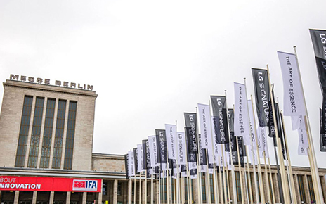 Partial view of Messegelände Berlin ExpoCenter City with promotional flags of the LG SIGNATURE brand and its brand theme “The Art of Essence” flying in front