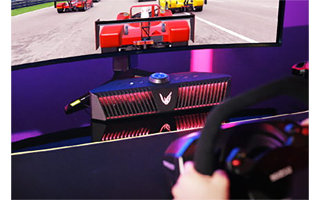 A gamer playing a game on an LG UltraGear gaming monitor connected to an LG UltraGear Gaming Speaker (model GP9)