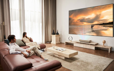 Use scenario of LG CineBeam – Two people are watching the projected screen in a living room