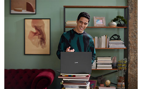 A amn using LG gram by putting the device on the stack of books