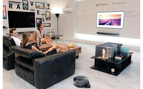 Models pose with LG ThinQ AI TV at the LG booth at IFA 2018.