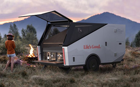 A photo of the updated version of Bon Voyage by LG Labs in the mountains with a woman standing next to it