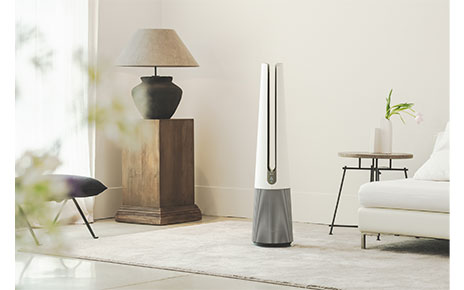 A front view of LG PuriCare AeroTower Beige air purifying fan in a bright room next to traditional interior decoration.