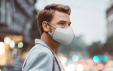 A man on a street wearing LG PuriCare wearable Air Purifier