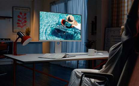 A user listening to a music playlist displayed on the LG MyView Smart Monitor at desk