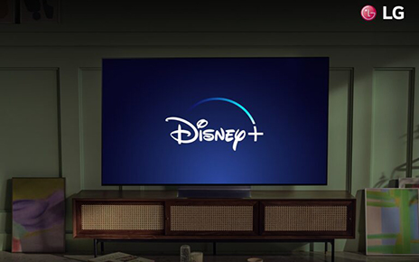 An LG TV in a living room displaying the Disney+ logo to celebrate the streaming service coming to more LG Smart TVs