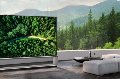 LG 8K OLED TV showing a road in the woods is placed in a spacious room with a spectacular view.