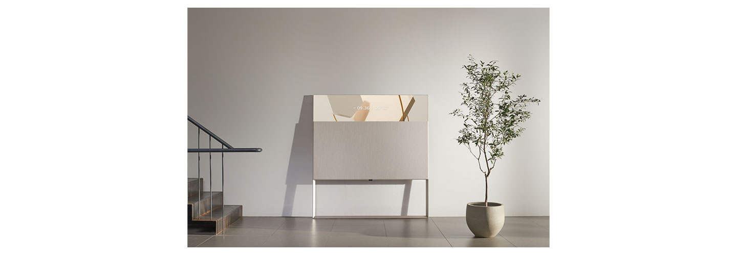 LG’s beige Objet TV leaning against the wall as it displays the date and time in its Line View mode.