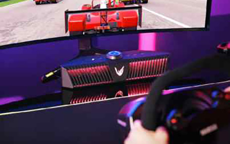 A gamer playing a game on an LG UltraGear gaming monitor connected to an LG UltraGear Gaming Speaker (model GP9). 