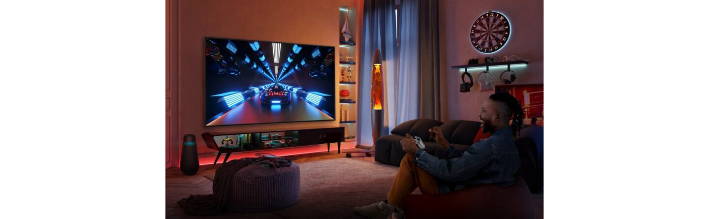 A gamer playing a racing game in a dimly lit living room via cloud gaming