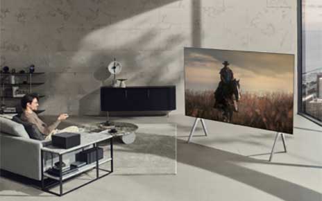 A man watching a TV series on the new LG OLED M3 while sitting on his living room sofa