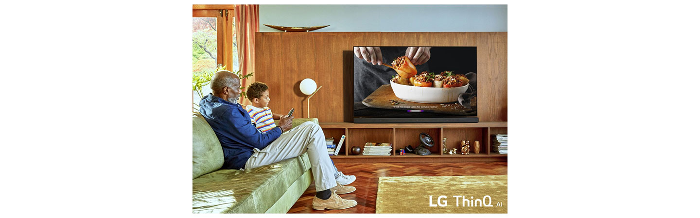 A granddad and grandson watch their LG OLED TV with LG ThinQ AI in their home