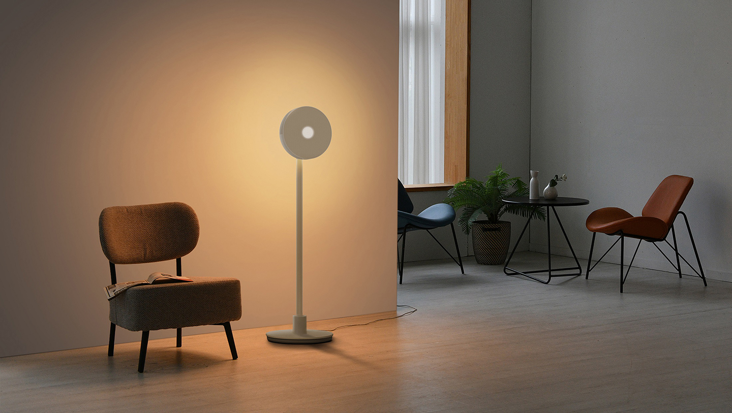 In a living room with a couple of chairs lie LG Projector PF600U lighting a wall, setting a warm tone to the room