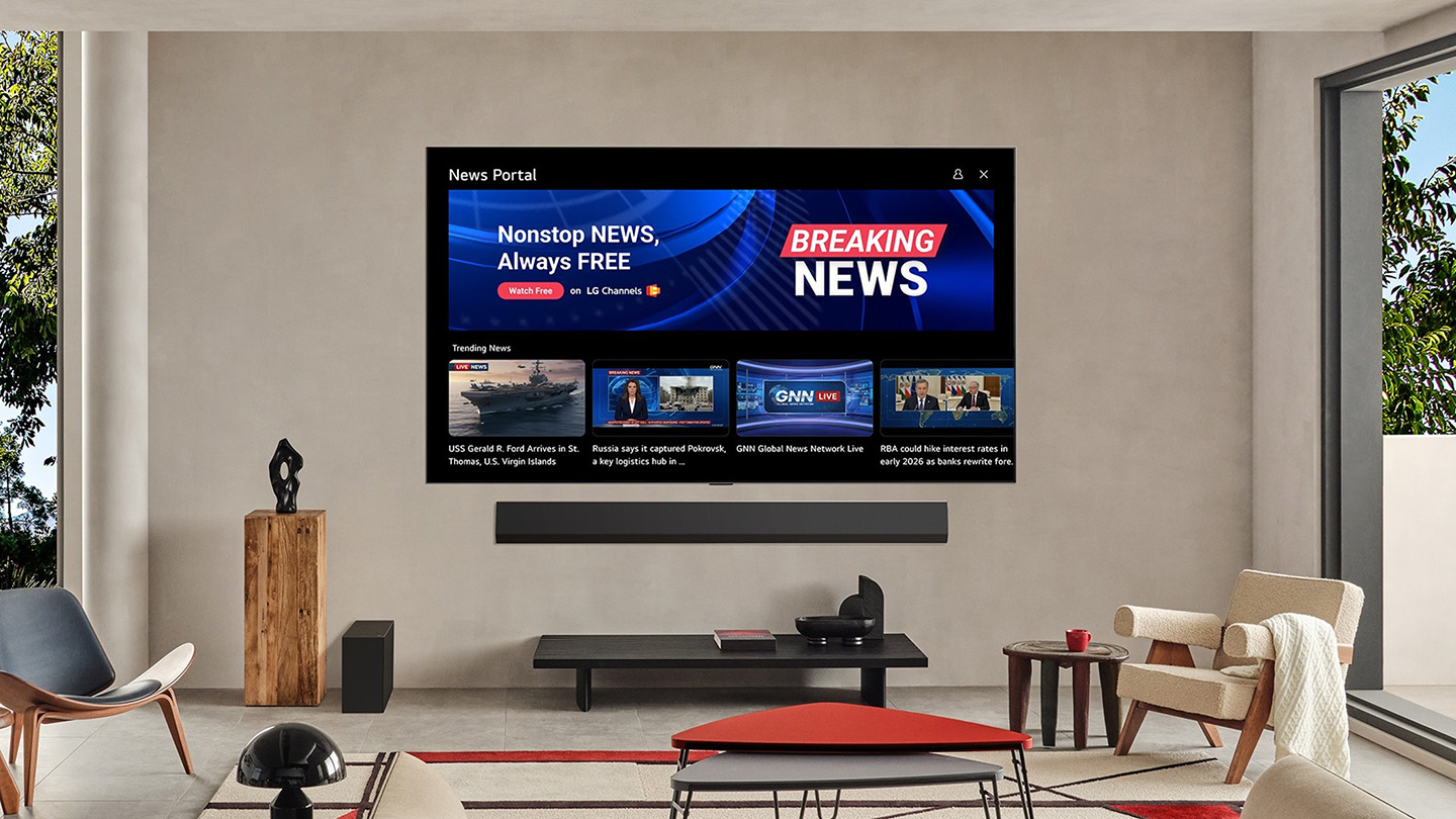 An LG Smart TV and soundbar are mounted to the wall of a modern living room, with the screen displaying the webOS News Portal interface.