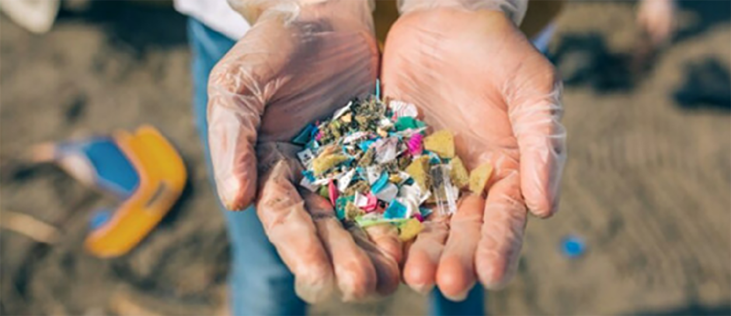 A photo of hand full of trash picked up with plastic gloves on 
