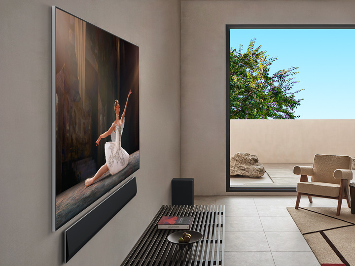 Living room inside a premium home. Angled side view of a wall-mounted LG OLED TV. It can be seen that there is no gap between the TV and the wall. 
