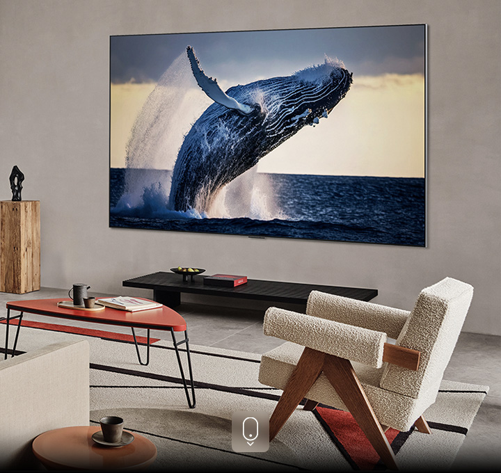 LG 4K TV mounted on the wall, screen showing a whale leaping out of the water in high quality 4k ultra hd resolution in a living room.