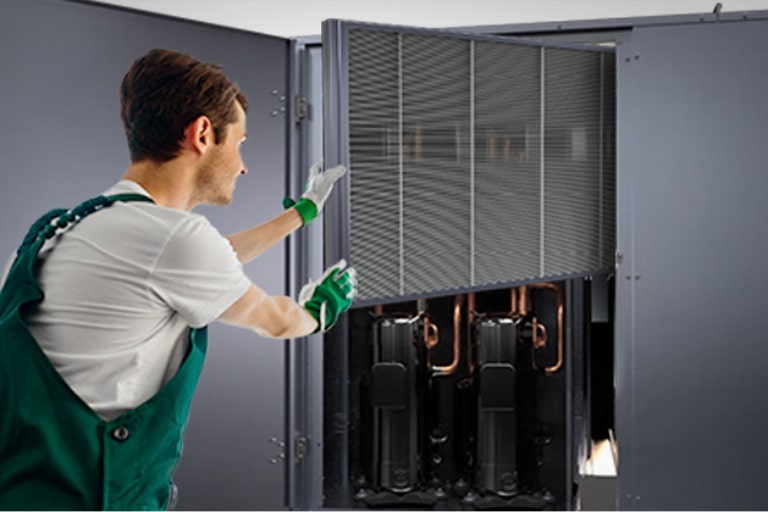 A man, wearing a glove, is extracting a rectangular-shaped filter from the LG Inverter Single Package.