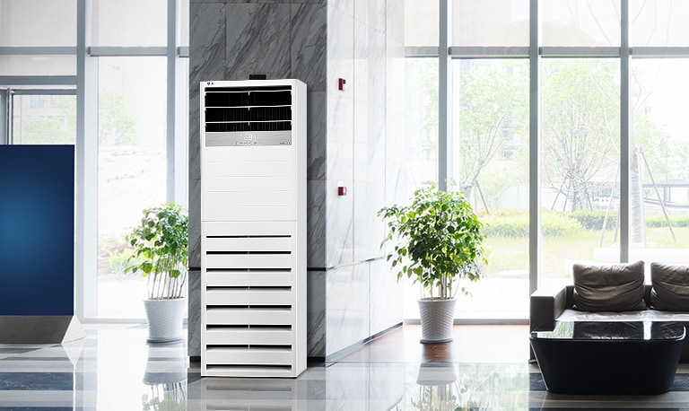 LG Floor Standing Unit is positioned in front of a marble pillar in the lobby area of a modern hotel, flanked symmetrically by two plants.