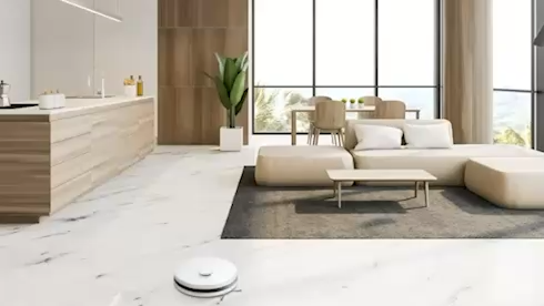 A blue light glows from the top of the LG CordZero™ as it scans the living room floor with its LiDAR sensor.