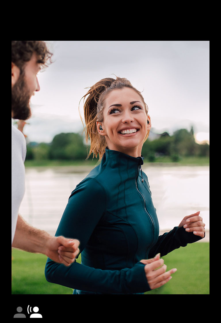 A man and woman running in a park wearing TONE Free fit.