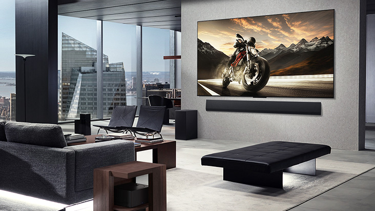 Wall-mounted LG OLED M5 TV and LG Soundbar in the living room of a classy apartment. Zero Connect Box hidden underneath a side table.	