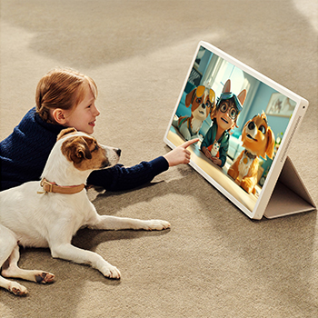 A girl with her puppy is watching a show on the LG StanbyME 2. The folio cover is used and the screen is propped up like a tablet. 