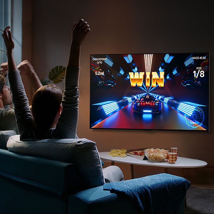 People play a game with a controller on the LG OLED television