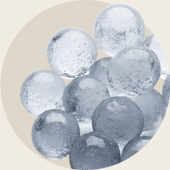 A pile of small, clear round ice balls stacked together.