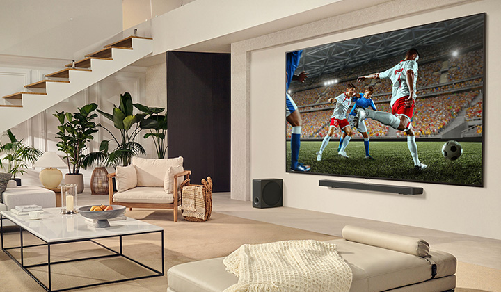A family is gathered around their LG Ultra Big TV watching an exciting soccer match on the huge screen.