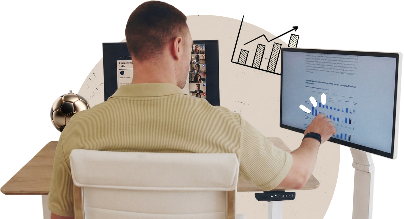 The back of a man touching an LG Smart Monitor Swing smart screen displaying data, next to a laptop showing a video meeting.