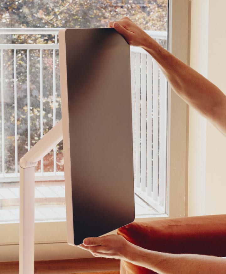 Two hands holding the top and bottom edges of an LG Smart Monitor Swing screen in portrait mode.