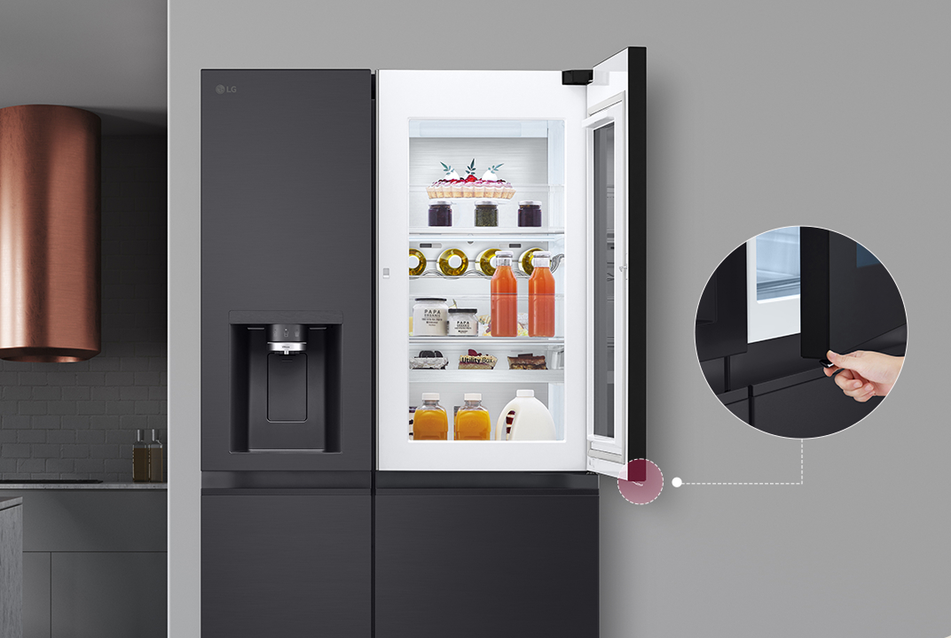 LG refrigerator with the outer door compartment opened and a hand pressing the release button illustrates Door-in-Door quick access storage.