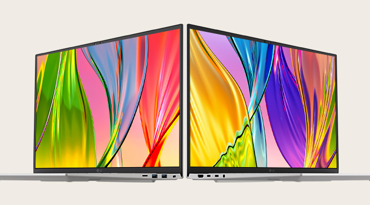 The image features two laptops placed back-to-back, showcasing vibrant, colourful screens with thin bezels, emphasising vivid visuals and sleek design.