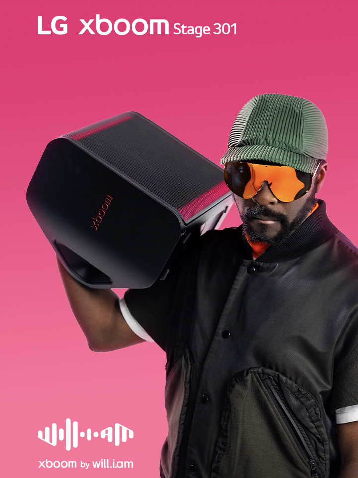 will.i.am in black outfit and sunglasses is holding xboom Stage 301 on his shoulder.