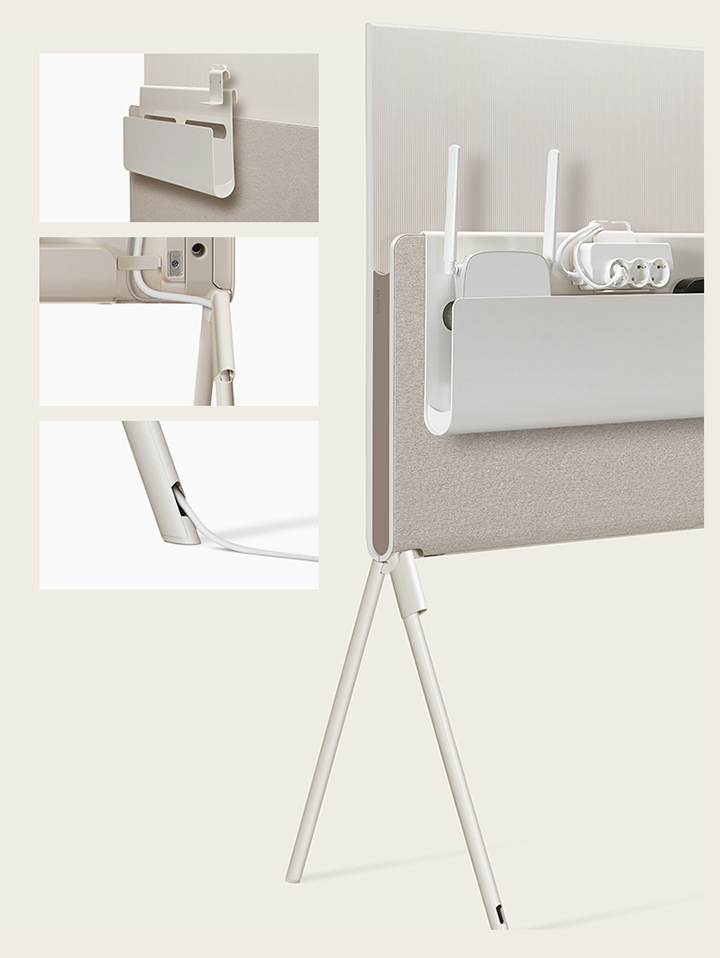 LG OLED Posé’s Cable & Accessory Organiser hangs from the Media Shelf.   LG OLED Posé’s detachable cable holder is seen closeup on the base of the TV.   LG OLED Posé’s cable is seen closeup running out of the TV leg.   LG OLED Posé is seen from the back with the Cable & Accessory Organiser holding a router, outlet, and device.