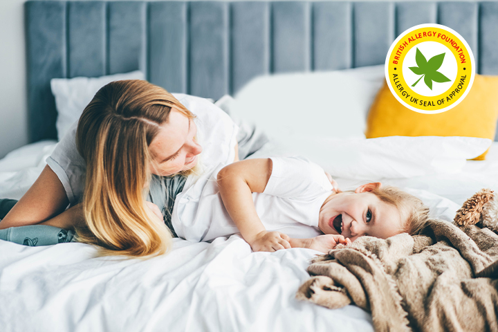 The child and mother are lying on the bed.