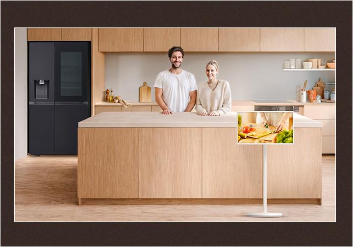 Image of a neat kitchen and a couple looking straight ahead with happy smiles