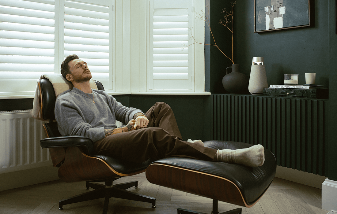 Relaxing on the Living Room Armchair and Enjoying Music with XBoom Speaker