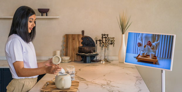 Lisa Mistry is brewing tea at the breakfast bar while watching a video on how to brew tea on her LG StandbyME.
