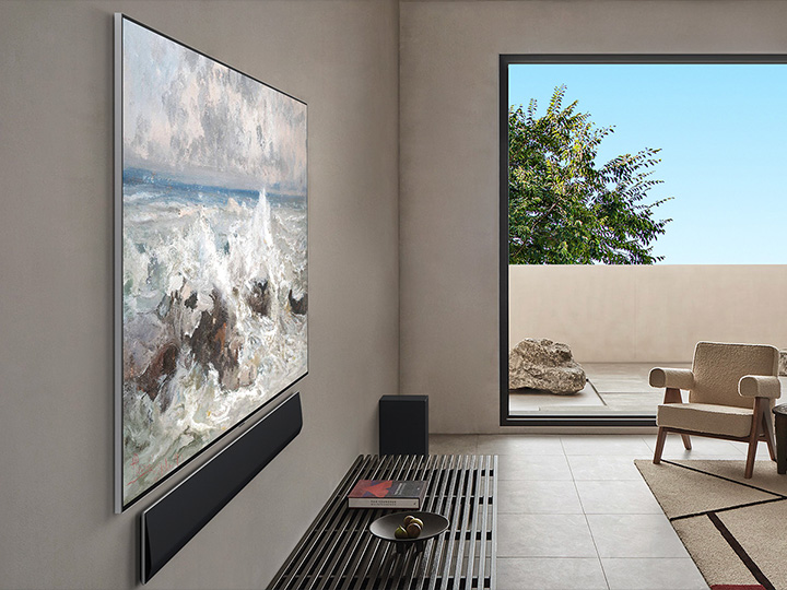 Living room inside a premium home. Angled side view of a wall-mounted LG OLED TV. It can be seen that there is no gap between the TV and the wall. 