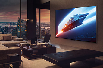 Classy living room in a penthouse apartment. Beautiful cityscape visible outside the window. A man is sitting on the couch watching content on the wall-mounted TV. 