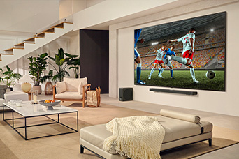 A family is gathered around their LG Ultra Big TV watching an exciting soccer match on the huge screen.