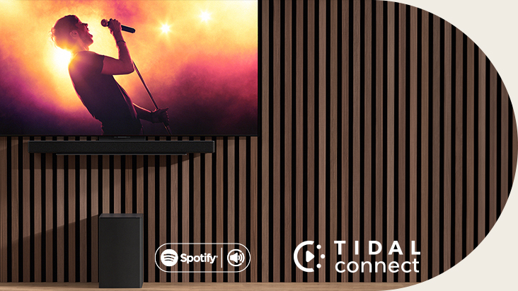 LG OLED C is placed on the wall, below LG Soundbar SC9S is placed through an exclusive bracket. Subwoofer is placed underneath. TV shows a concerts scene.	