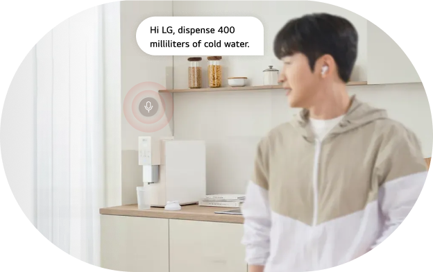 An image of the LG water purifier AI voice command feature. A man in the kitchen faces the LG water purifier and issues a voice command shown in a speech bubble. Command: 'Hi LG, dispense 400 ml of cold water.'