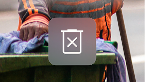 An image of a sanitation worker in an orange uniform managing a trash bin, overlaid with a trash can icon.